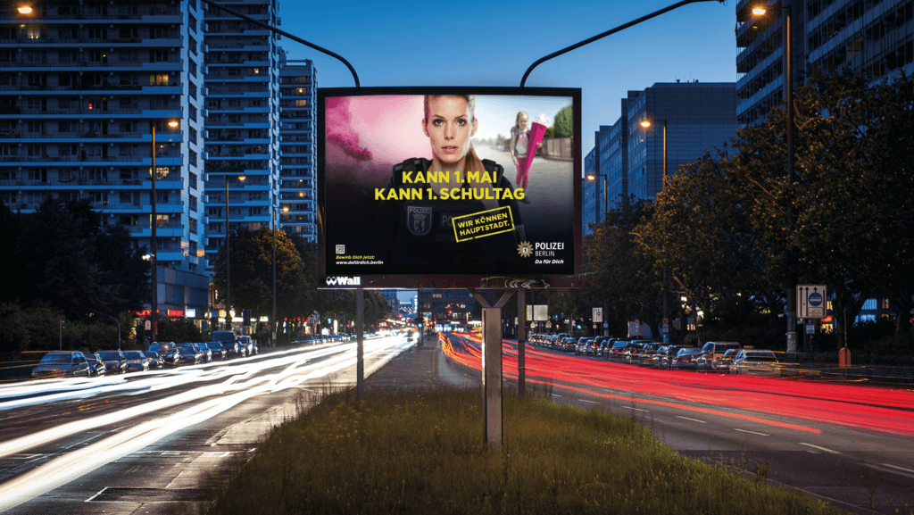 Plakat der "Wir können Hauptstadt" Kampagne von glow für die Polizei Berlin an einer befahrenen Straße