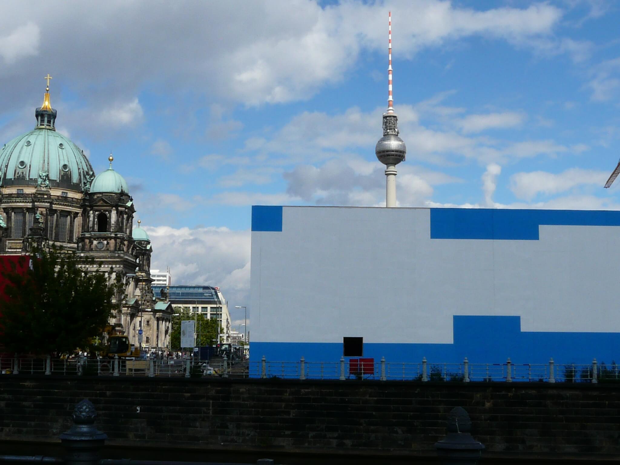 Foto der Temporären Kunsthalle in Berlin. Im Hintergrund sind der Fernsehturm und das Reichstagsgebäude zu sehen.