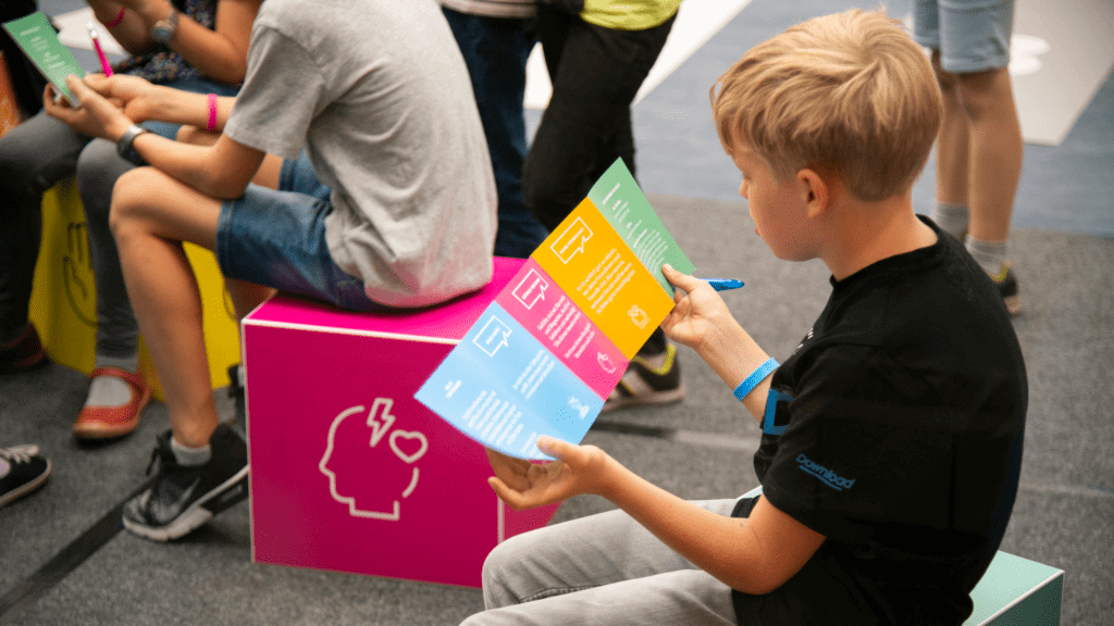 Ein Junge mit einem Flyer beim Klick-Clever Event von Innocence in Danger