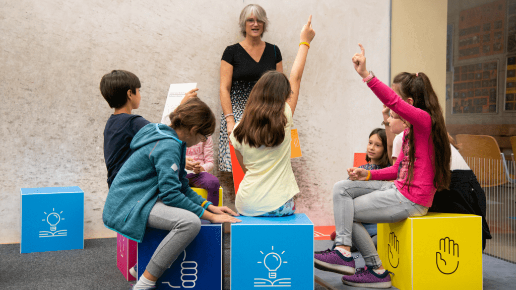 Eine Sprecherin und Kinder, die sich an der Diskussion beteiligen.