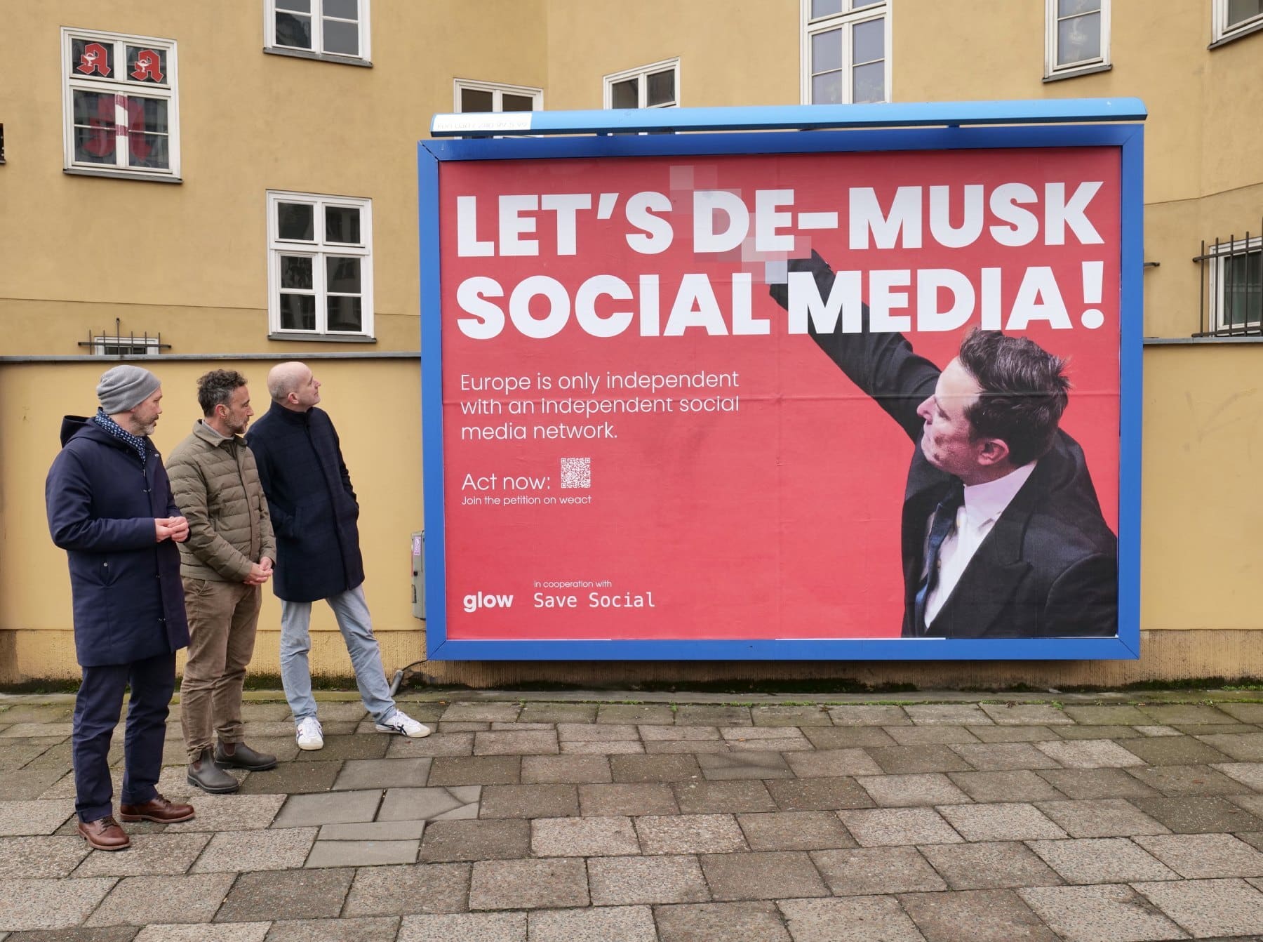 Sebastian Wilke, Johannes Meissner (beide glow) und Björn Staschen (SaveSocial.eu) vor dem Plakat in der Torstraße